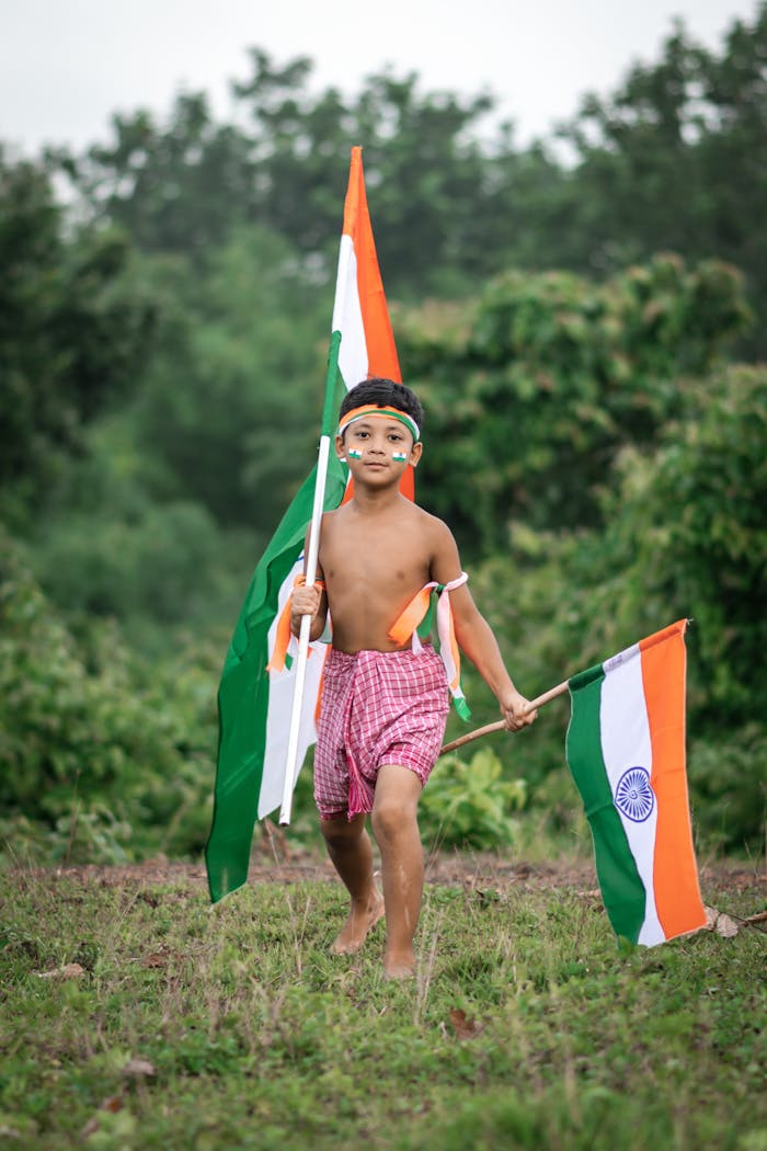 gallery-3 A young Indian boy joyfully waving the national flag outdoors, symbolizing Indian independence.